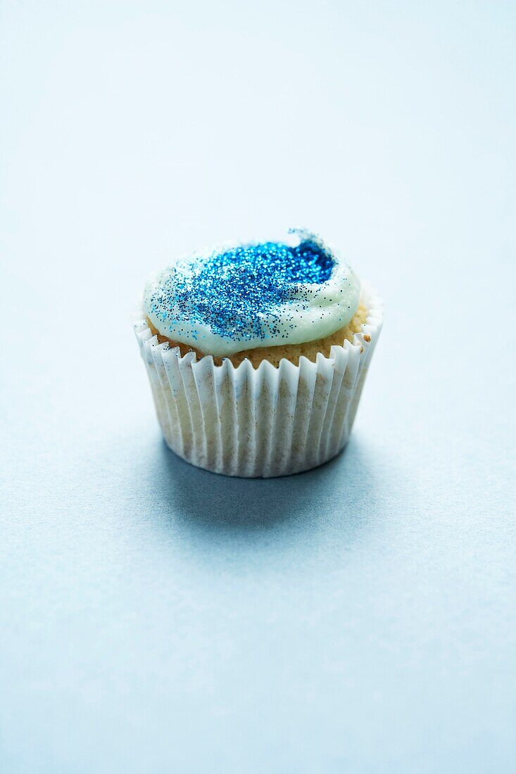 Blauer Glittery-Cup-Kuchen auf weißem Hintergrund