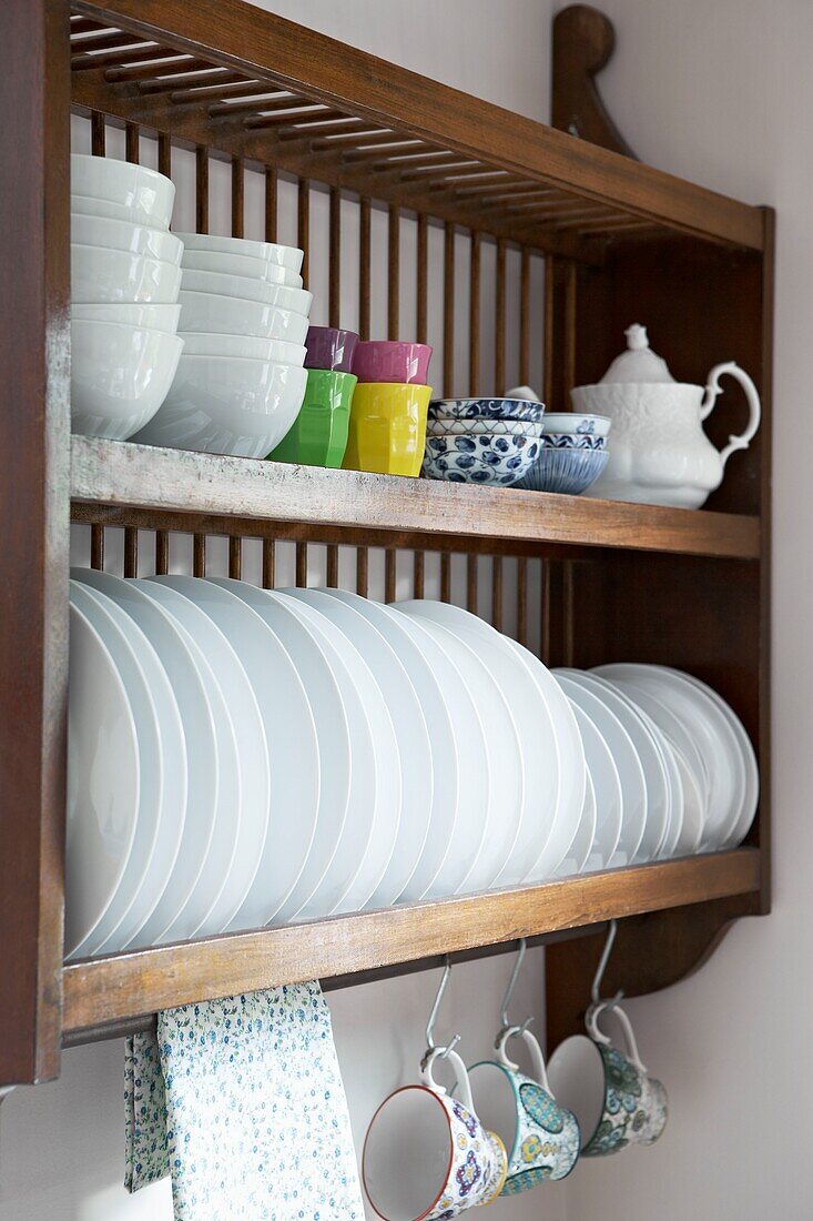 Plates and bowls on storage rack in kitchen of London home   UK