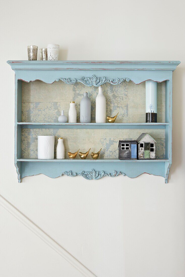 Blue wall mounted cabinet with homeware in London home   UK