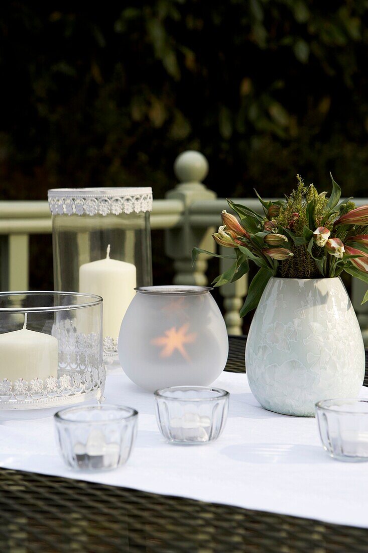 Tischplatte im Garten mit Kerzen und Blumen