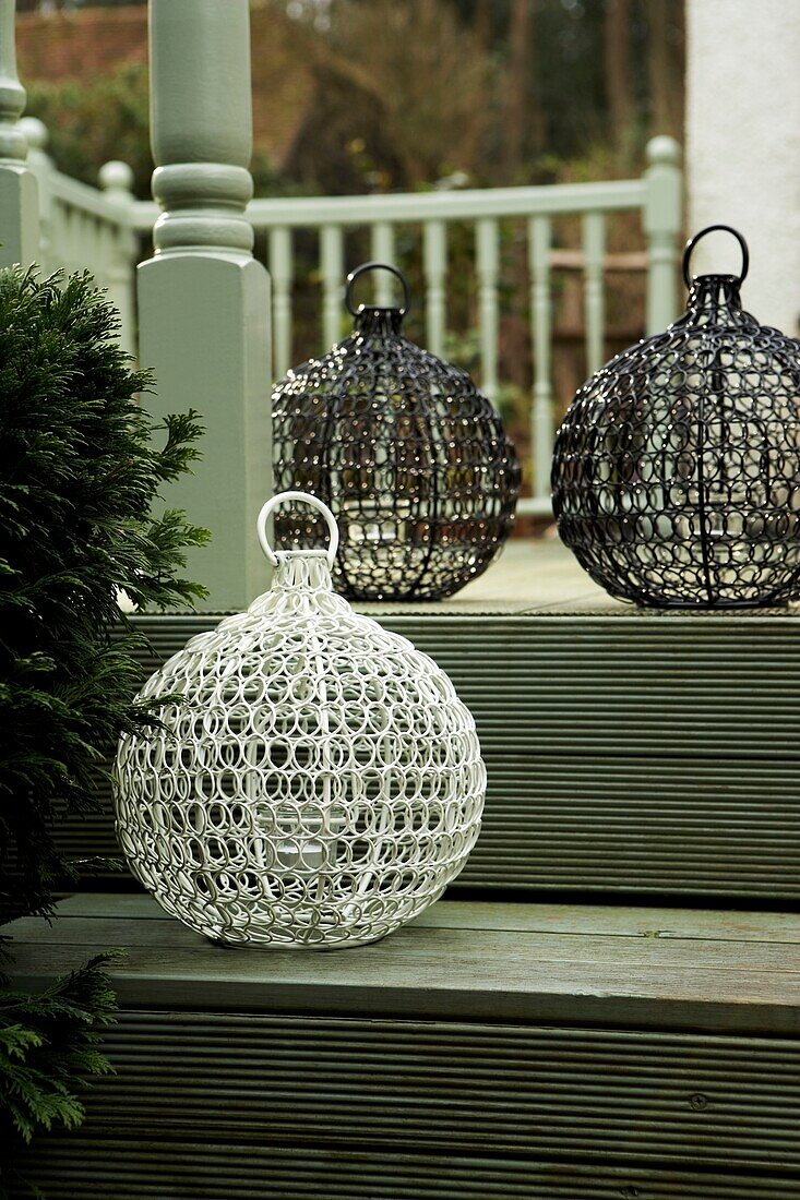 Large wirework lanterns on the steps of the veranda painted green