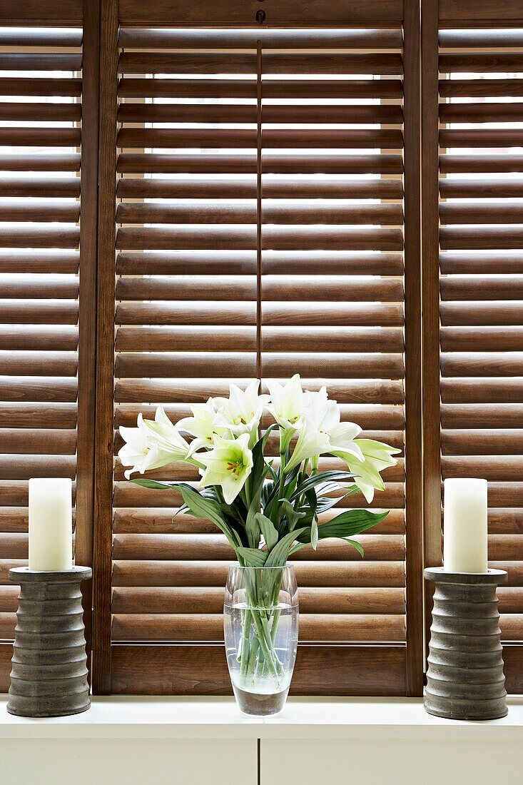 cut lilies with candle holders on windowsill of London home