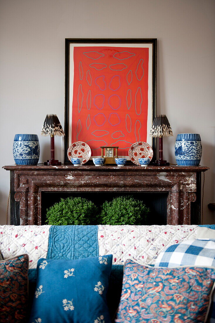 Sofa und Kunstwerk mit Ornamenten am Marmorkamin in einem Haus in Greenwich, London, England, UK