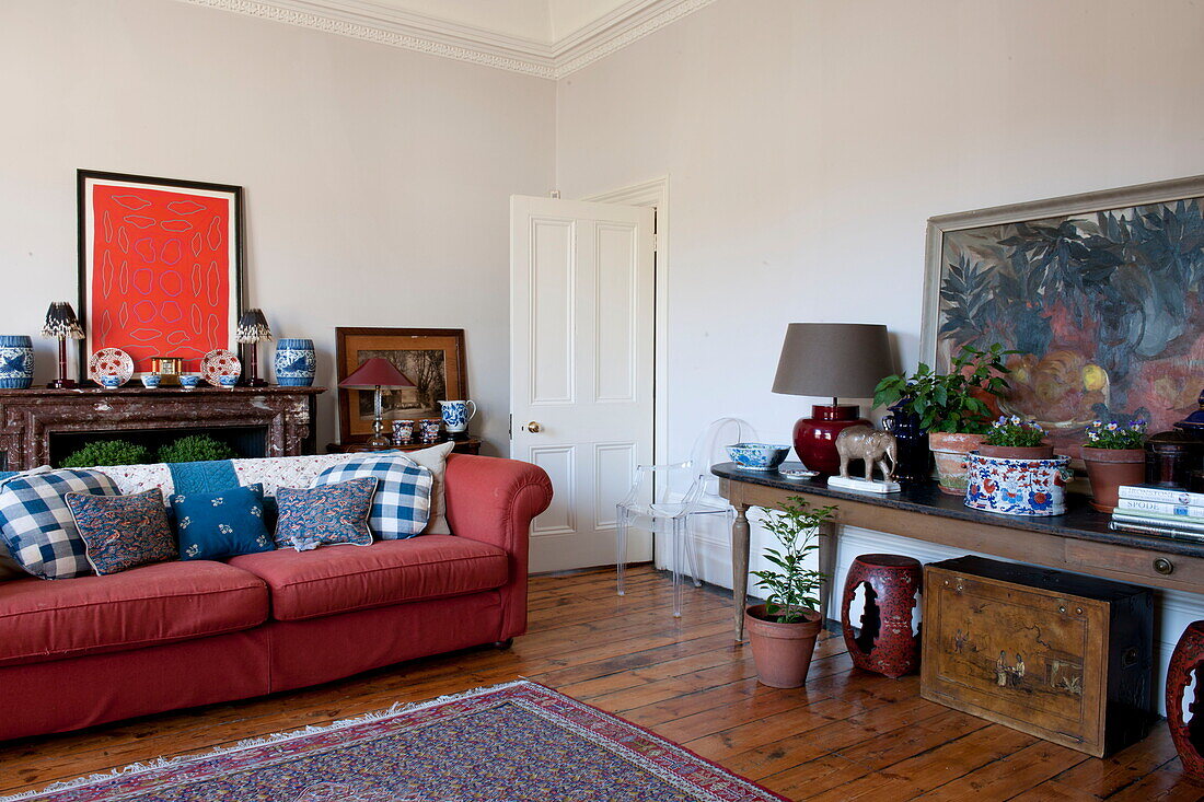 Rotes Sofa und Kunstwerk mit Konsole in einem Haus in Greenwich, London, England, UK