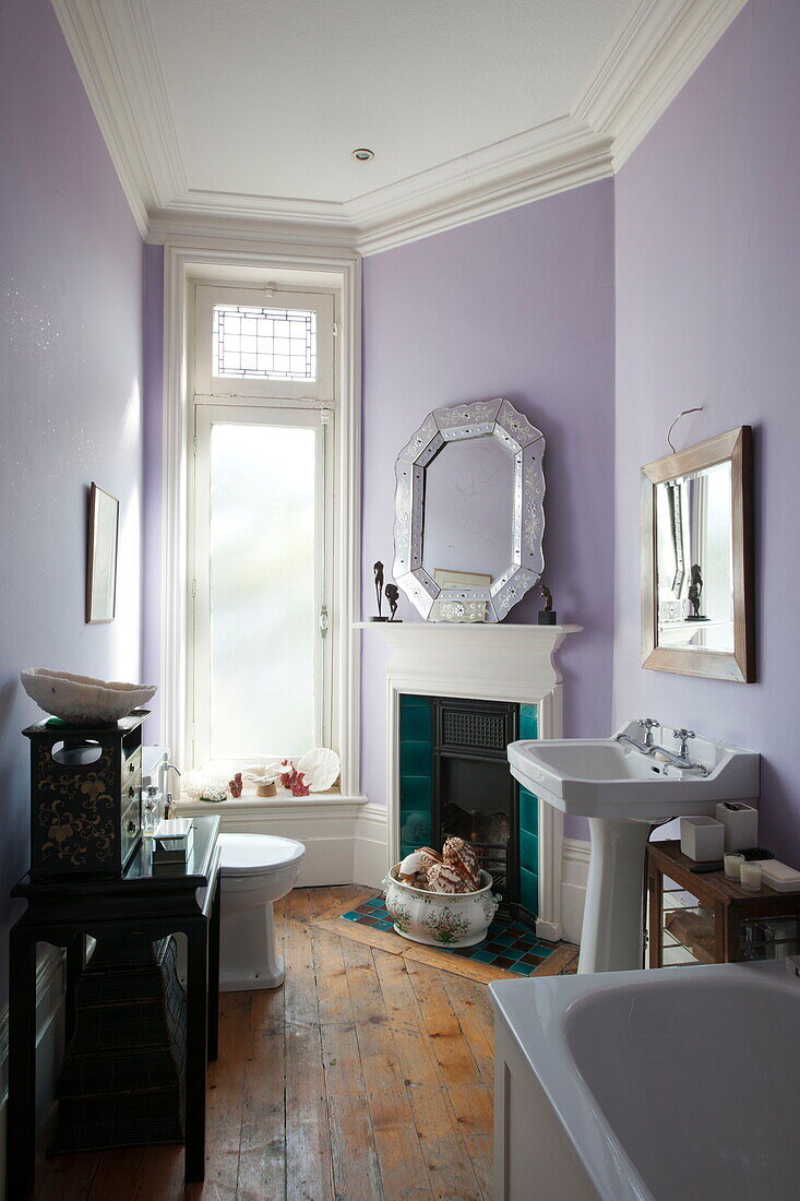 White bathtub and sink in lilac bathroom of  Greenwich home,  London,  England,  UK