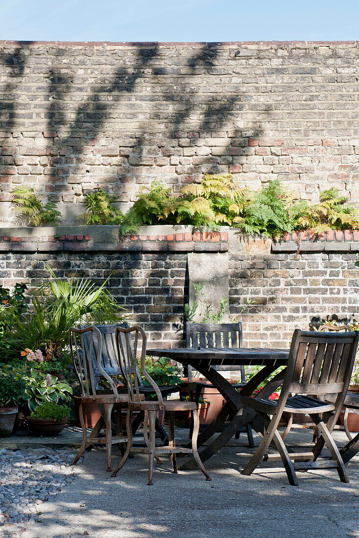 Hölzerne Gartenmöbel in gemauerter Backsteinfassade eines Hauses in Greenwich, London, England, UK