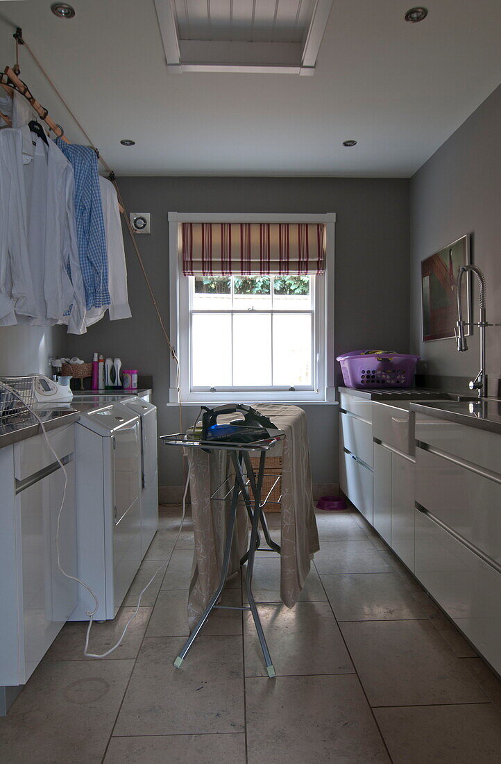 Ironing board in utility room of contemporary Haywards Heath home,  West Sussex,  England,  UK