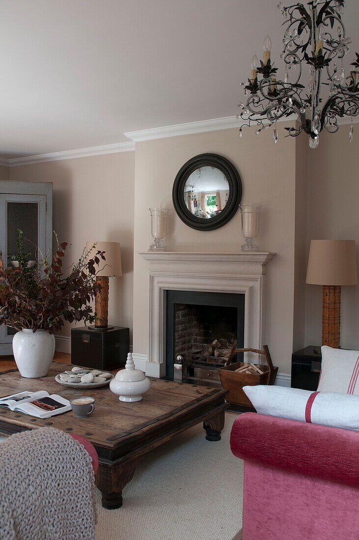 Low wooden coffee table in front of fireplace in living room of contemporary Haywards Heath home,  West Sussex,  England,  UK