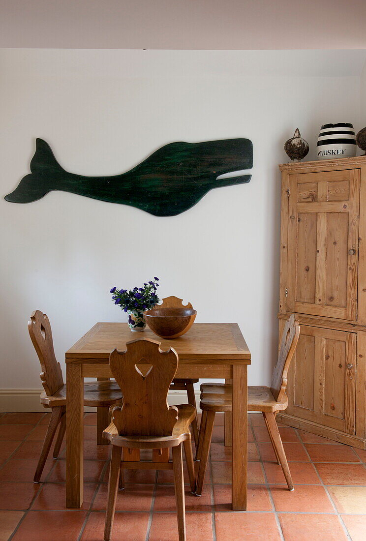 Holzstühle am Tisch mit ausgeschnittenem Wal in einem Haus in Ashford, Kent, England, UK