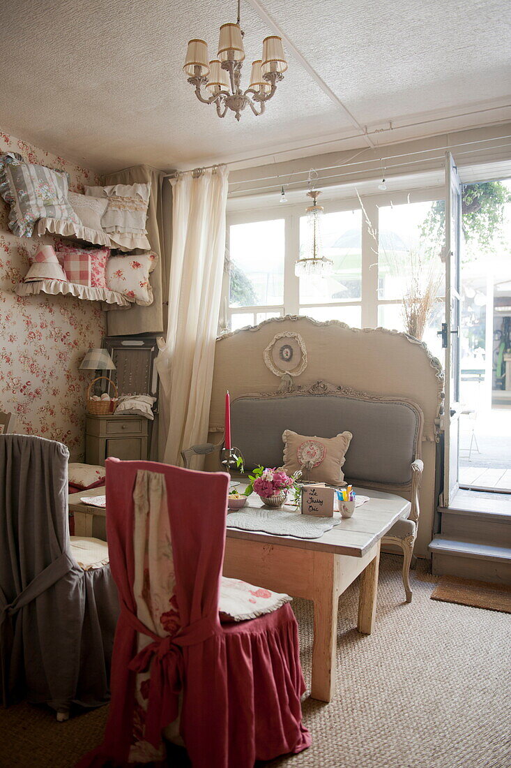 Stühle mit Stoffbezug und Holztisch am Fenster eines Teesalons in der Dordogne, Frankreich