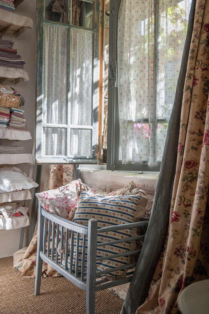 Cushions at light blue painted window of Dordogne farmhouse,  France