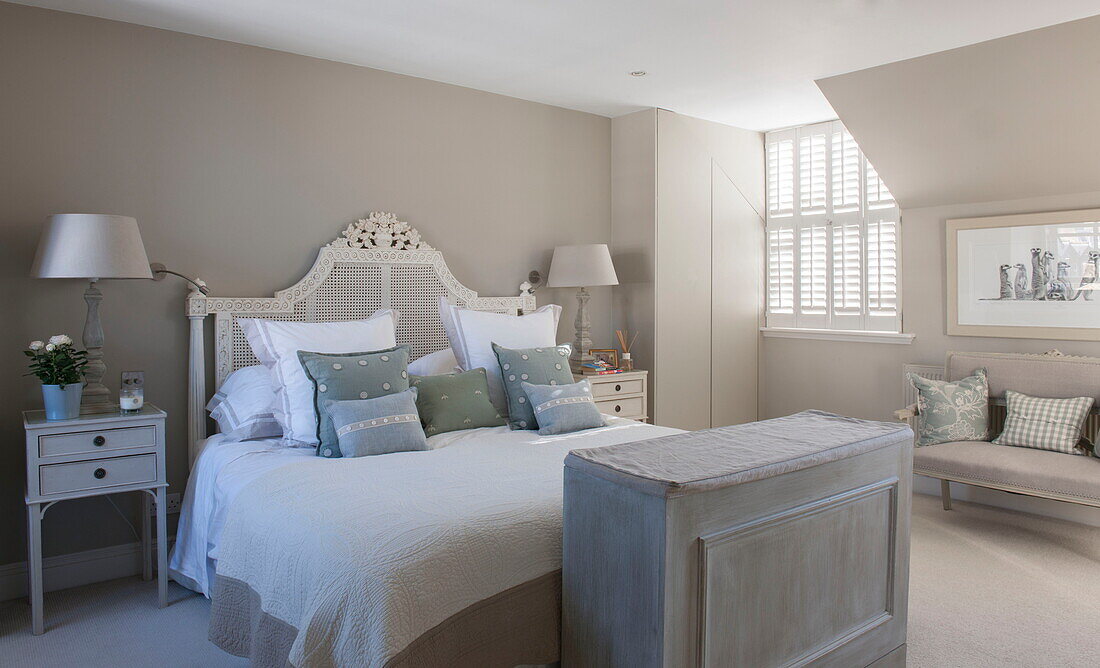 Double bed with wicker headboard in room with concealed storage Battersea home,  London,  England,  UK