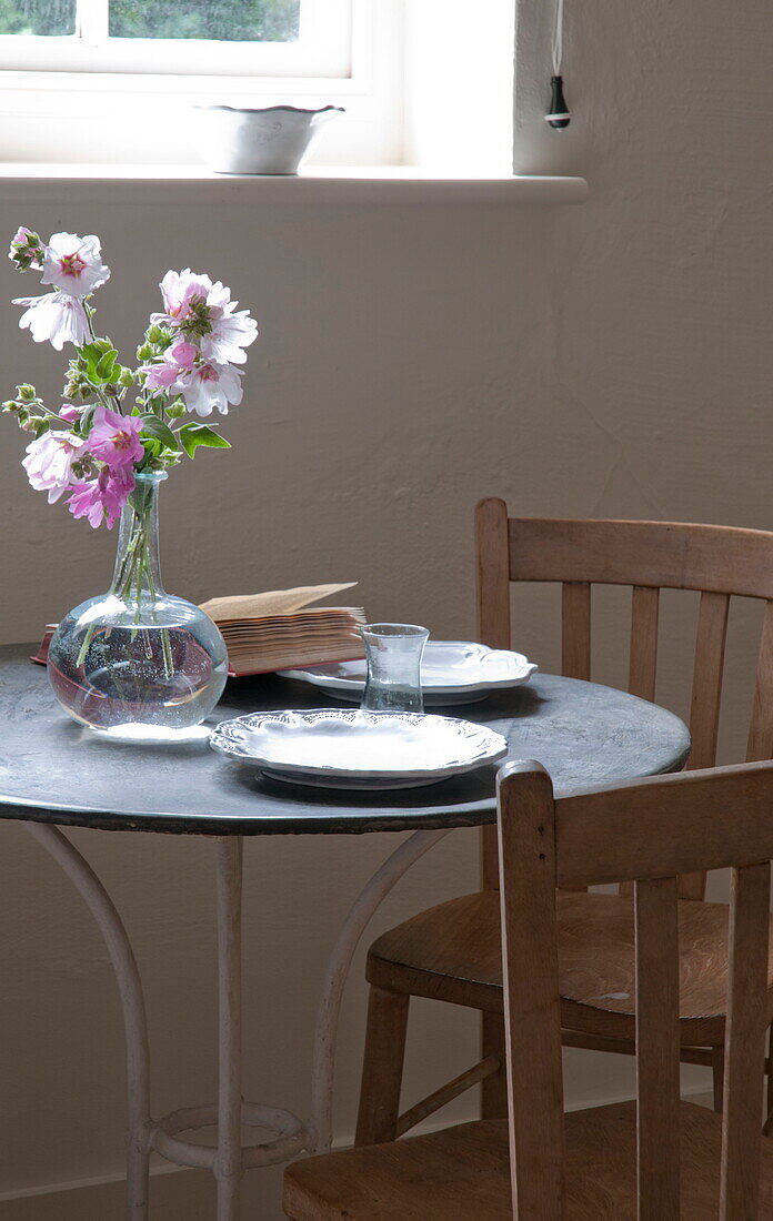 Cut flowers on circular table at window of Kingston home,  East Sussex,  England,  UK