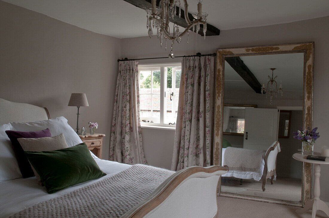 Grünes Samtkissen auf einem Doppelbett mit Spiegel in einem Haus in Kingston, East Sussex, England, UK