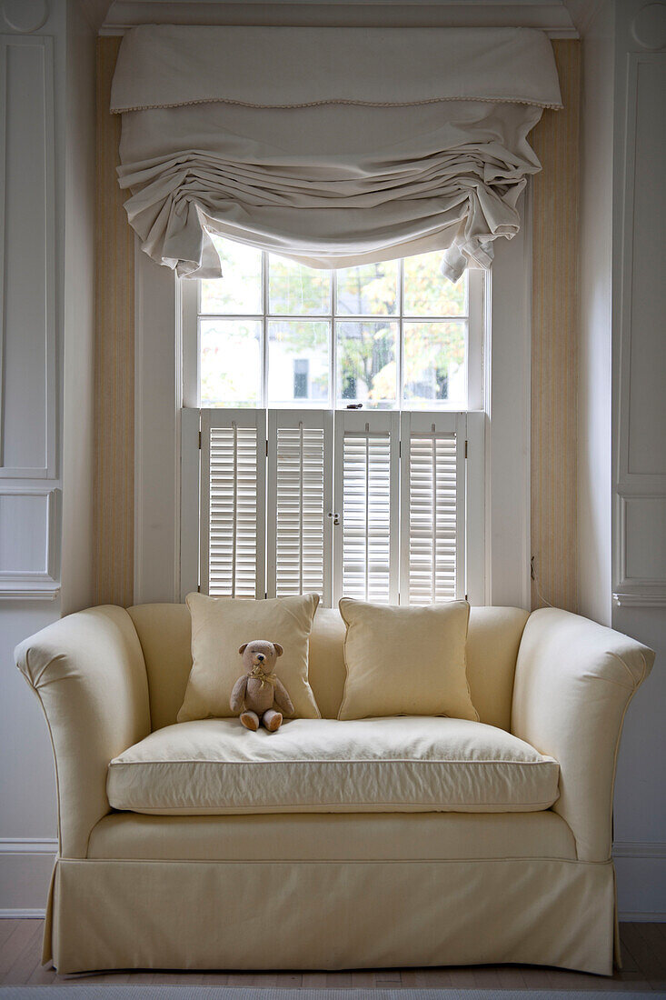 Teddybär auf Zweisitzer-Sofa am Fenster in Haus in Washington DC, USA