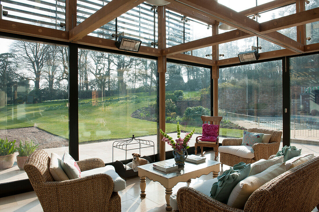 Three piece suite in conservatory of Tiverton country house with full length windows and view to garden,  Devon,  England,  UK