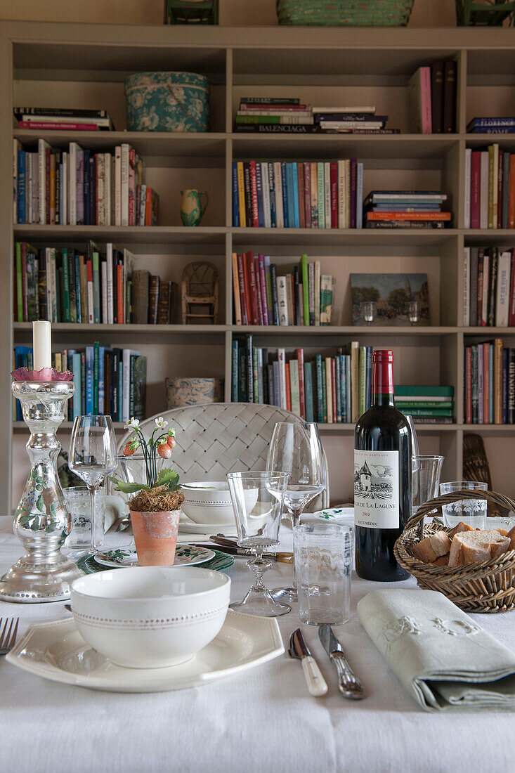 Rotwein auf Esstisch mit Bücherregal im Landhaus in der Dordogne Perigueux Frankreich
