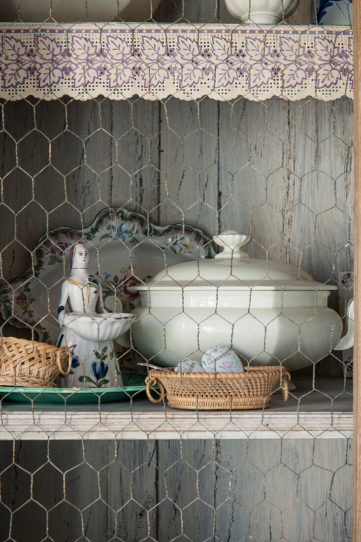 Küchenutensilien und Figur in Drahtgitterkommode im Landhaus Dordogne Perigueux Frankreich