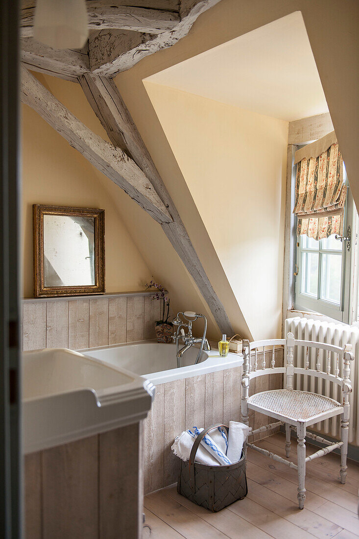 Spiegel mit vergoldetem Rahmen auf einem Regal in einem Badezimmer mit gelbem Holzrahmen in einem Ferienhaus in der Dordogne in Perigueux, Frankreich