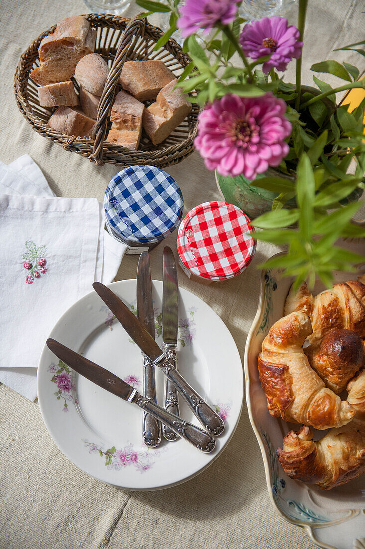 Messer auf Beistelltellern mit Croissants und Marmelade auf dem Tisch in der Dordogne Perigueux Frankreich