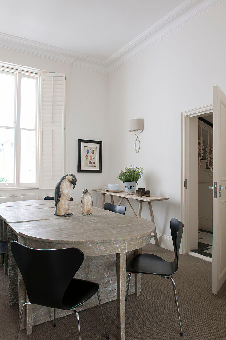 Black chairs at table with penguin ornaments in South Kensington townhouse  London  UK