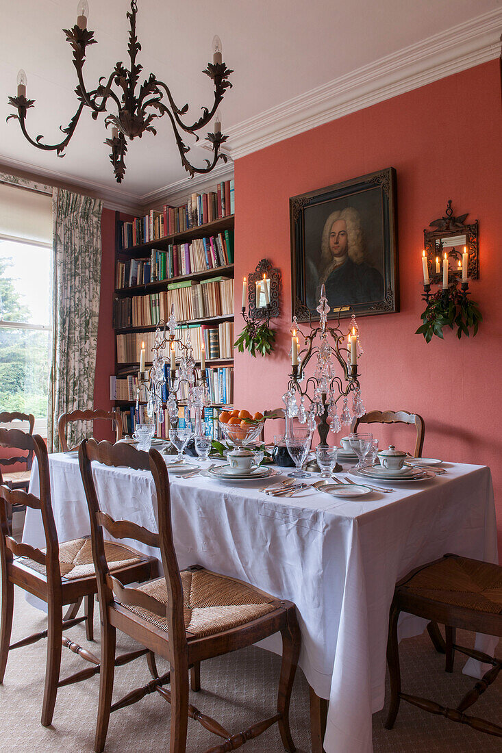 Esstisch mit Bücherregal und Glaskandelabern in London home England UK