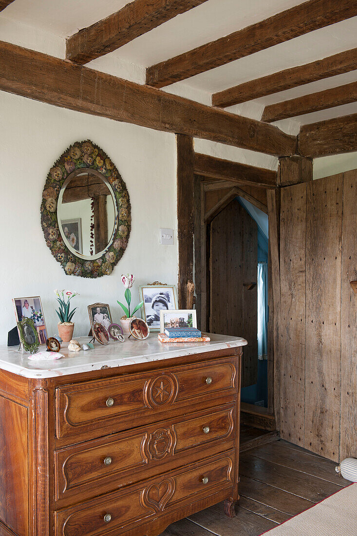 Mirror above antique wooden chest of drawers in High Halden cottage  Kent  England  UK