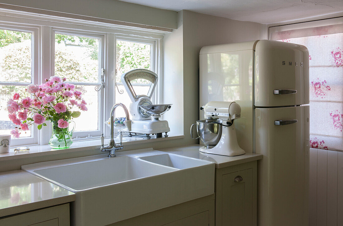 Food mixer and scale with double sink below window in Kent kitchen  England  UK