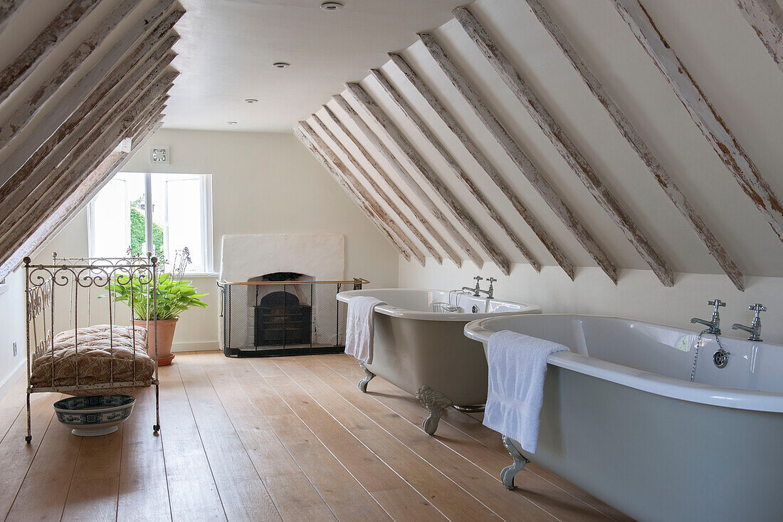 Dachgeschossausbau mit Balken und zwei freistehenden Badewannen in einem Haus in Kent, England, Vereinigtes Königreich