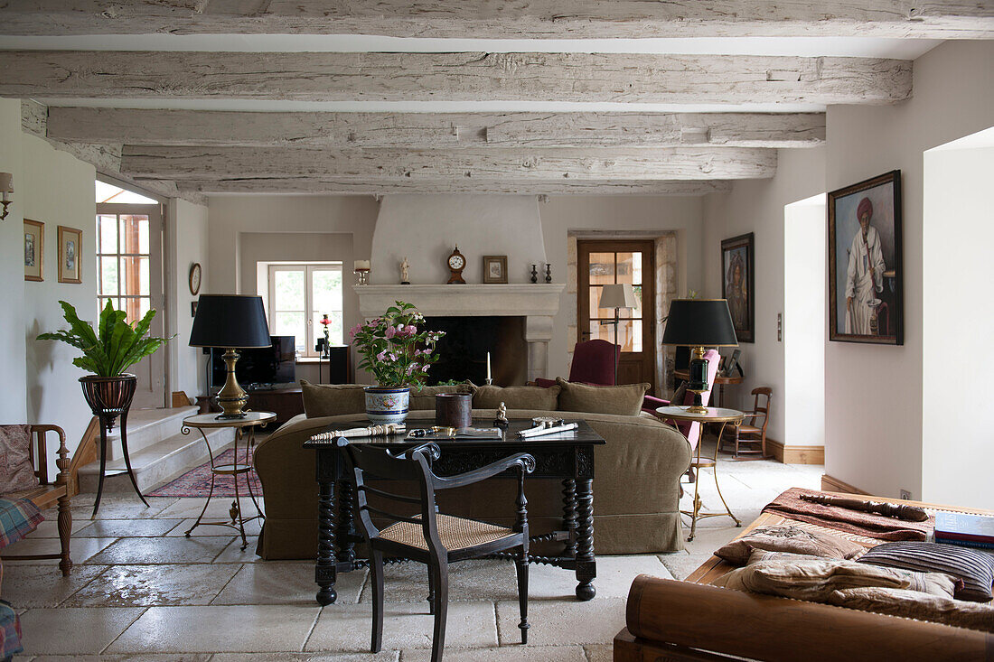 Offenes Balken-Wohnzimmer mit schwarzen Lampen in einem Landhaus in der Dordogne Perigueux Frankreich