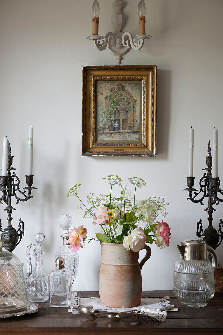 Terrakotta-Kübel und Kerzenständer mit geschnittenen Rosen auf hölzernem Sideboard in Dordogne Landhaus Perigueux Frankreich