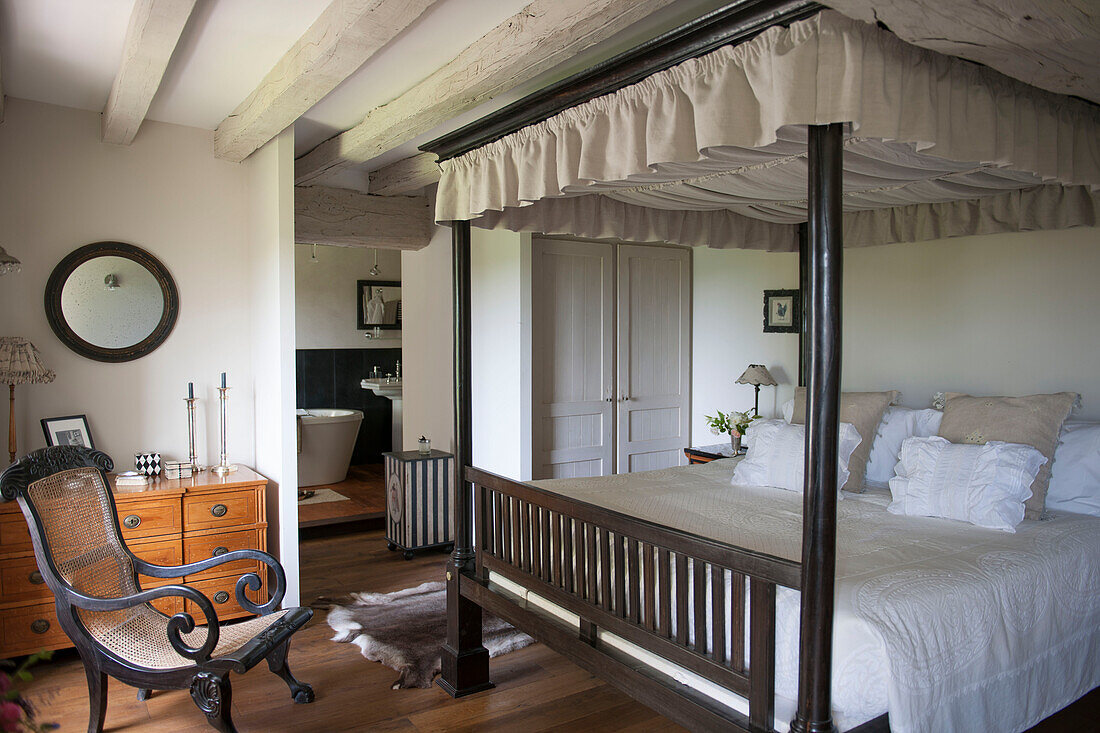 Antiker Sessel am Fußende des Himmelbetts in einem Bauernhaus in der Dordogne Perigueux Frankreich