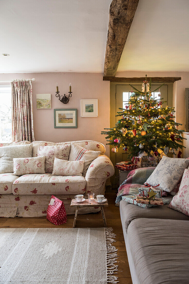 Weihnachtsbaum und Blumensofa im Wohnzimmer eines unter Denkmalschutz stehenden Hauses (Grade II) in Kent