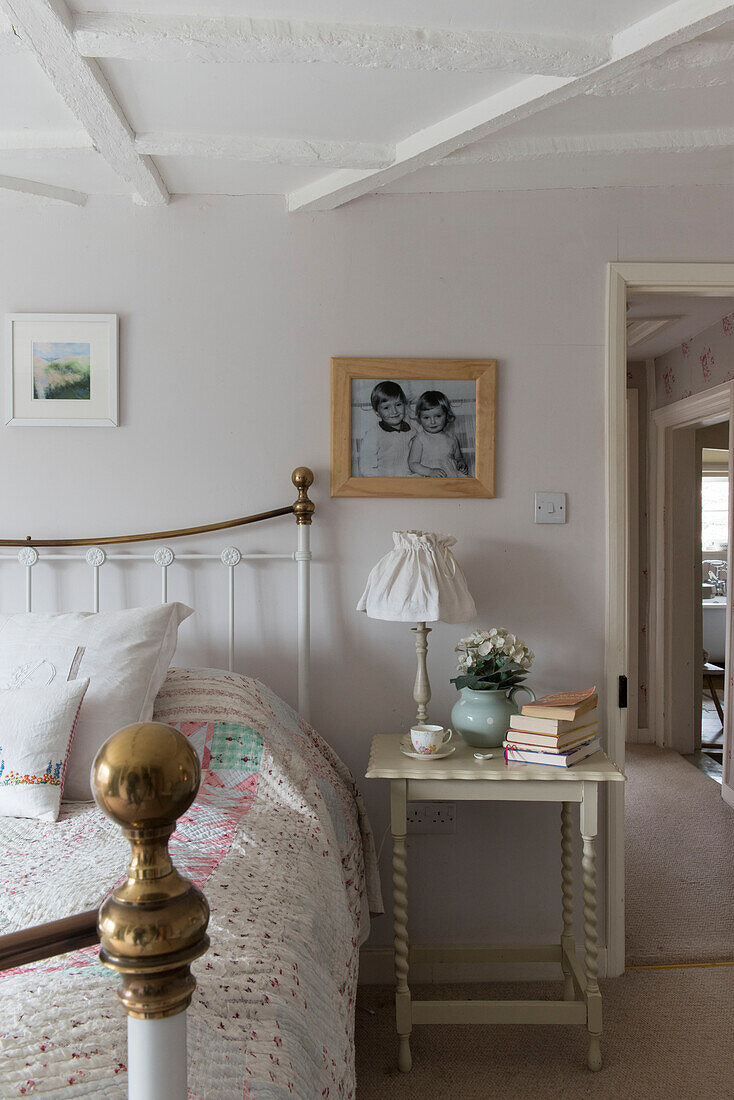 Brass bed with books on side table in Grade II listed cottage  Kent
