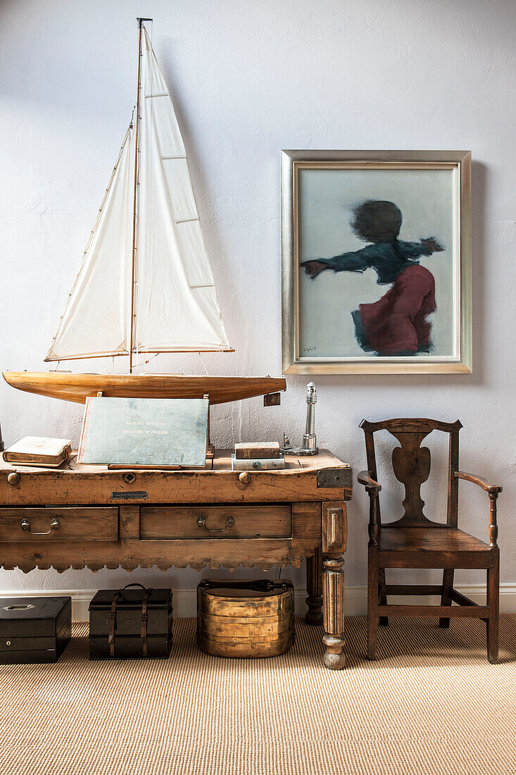 Modellboot auf antikem Tisch mit Stuhl und Kunstwerk in Norfolk coastguards cottage England UK