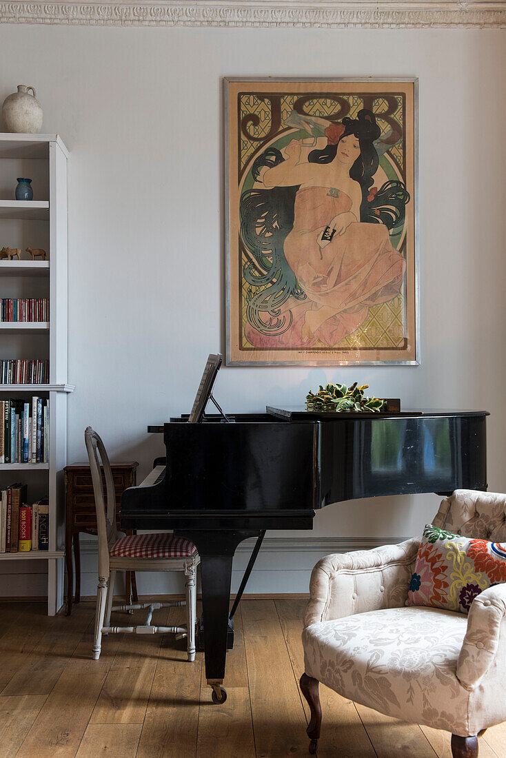 baby grand piano and art nouveau artwork with armchair in North London Victorian house  England  UK