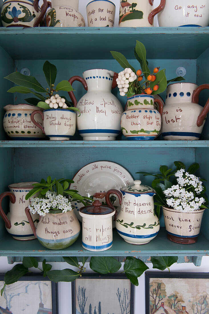 Collection of assorted vases with sayings on shelves in London home  England  UK