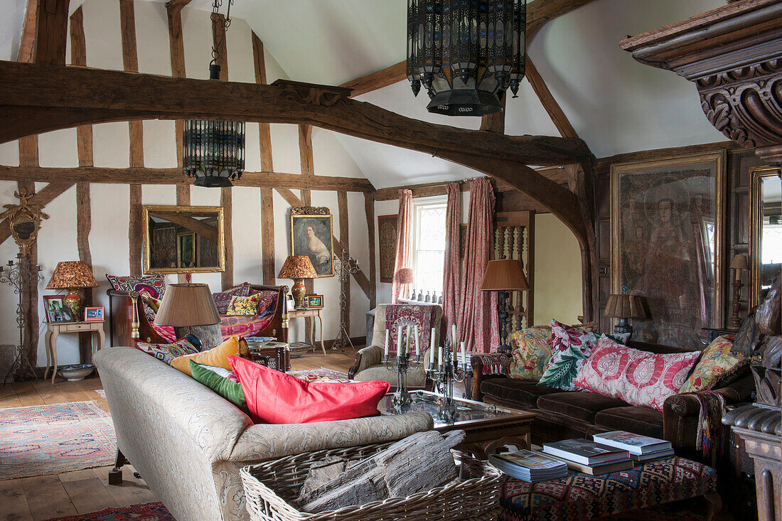 Holzkorb und Sofas im Wohnzimmer eines Hauses in Suffolk England UK