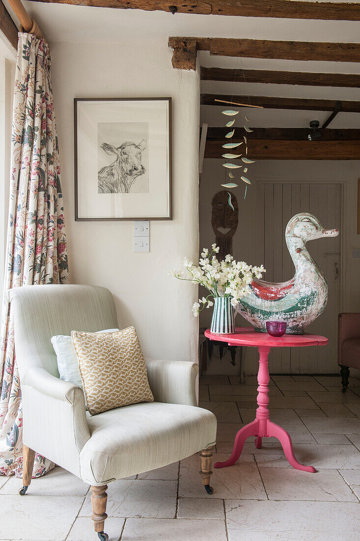 Große Ente auf rosa Beistelltisch mit Sessel in Suffolk-Bauernhaus England UK