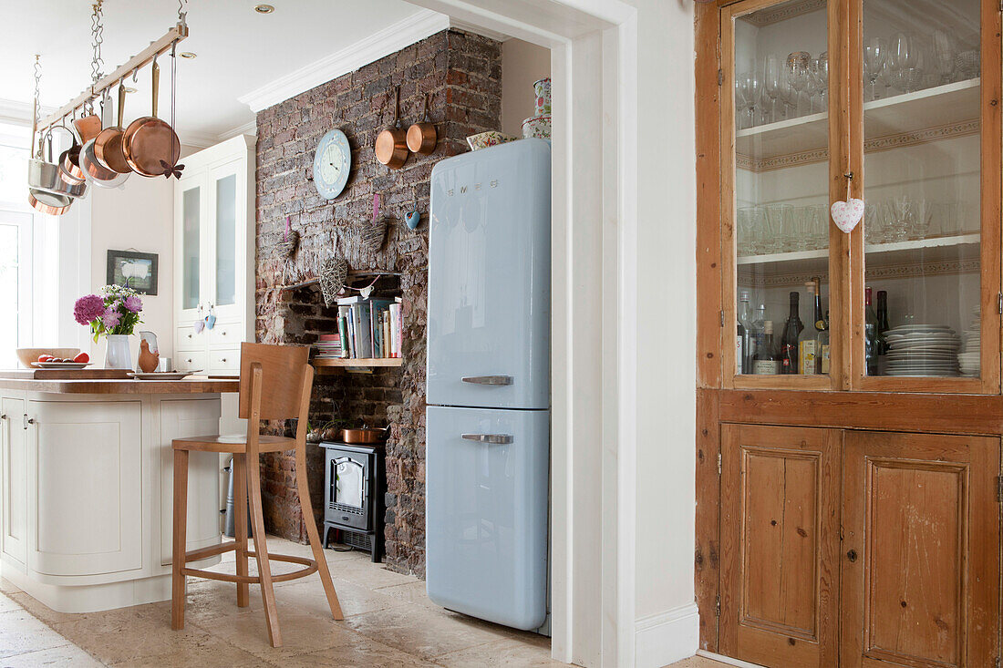 Hellblauer Kühlschrank und Holzschrank mit Glasfront in einer Küche in Brighton mit Sichtmauerwerk, East Sussex, England, UK