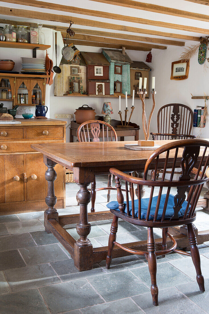 Holzstühle und Tisch mit Steinplattenboden in der Küche eines Cottage in Devon, England UK
