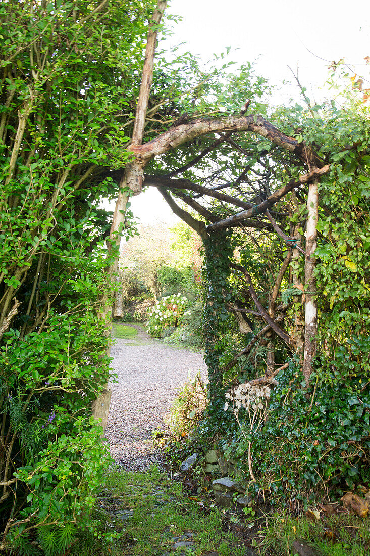Wooden pergola in garden with gravel driveway Devon England UK