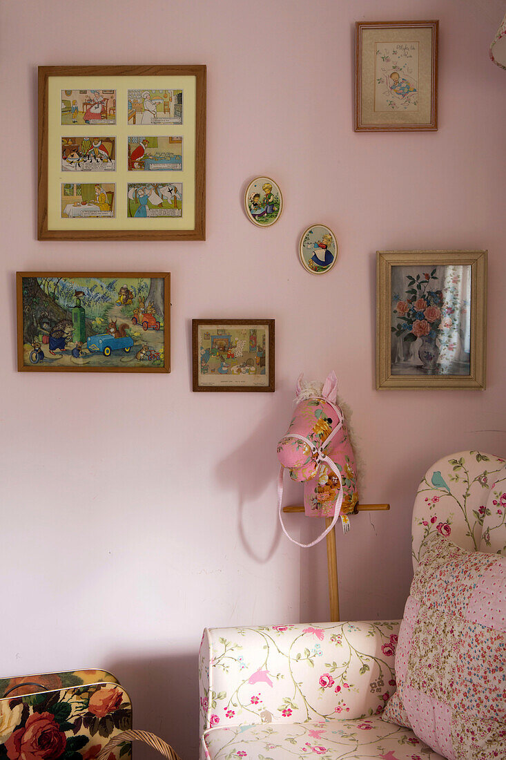 Hobby horse and armchair with artwork in girl's room of Amberley cottage West Sussex UK