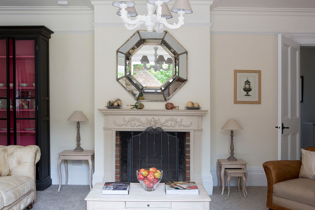 Octagonal mirror above fireplace in living room of Petworth farmhouse West Sussex Kent