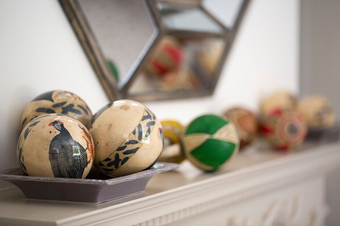 Collection of hand-painted balls on mantlepiece in Petworth farmhouse West Sussex Kent