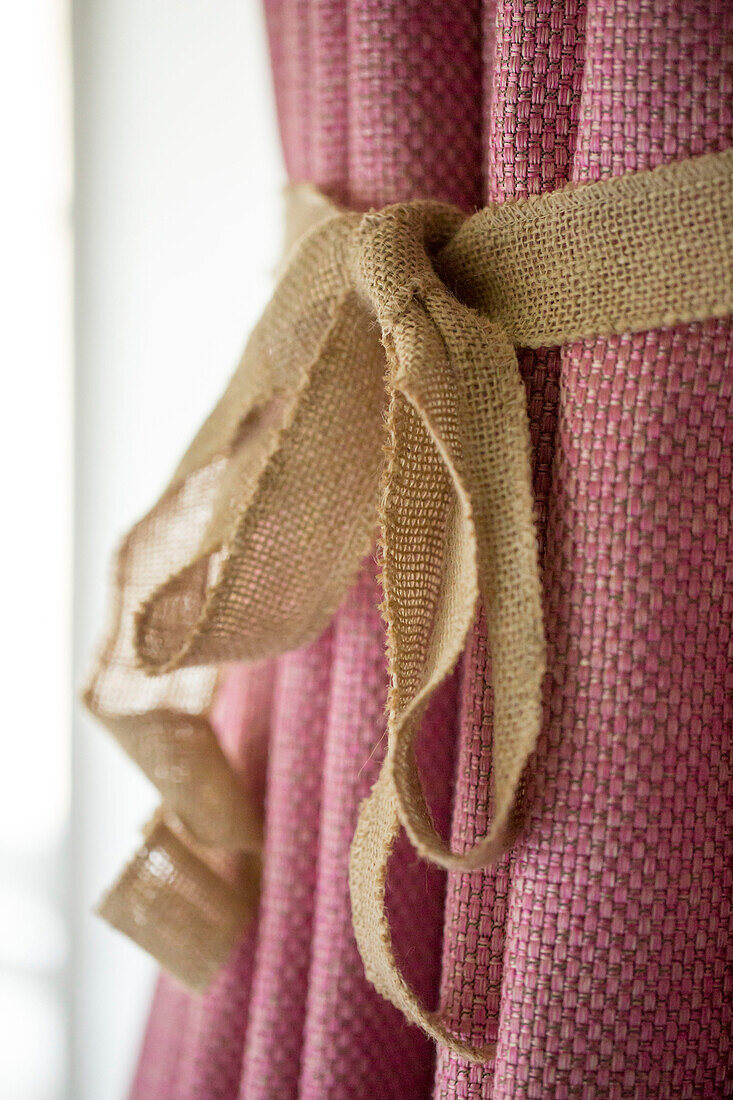 Hessian tieback on pink curtains in Petworth farmhouse West Sussex Kent