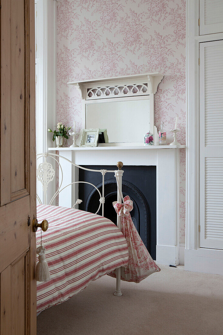 Blick durch die Tür auf eine gestreifte Bettdecke auf einem Doppelbett in einem Haus in Brighton, East Sussex, England, UK