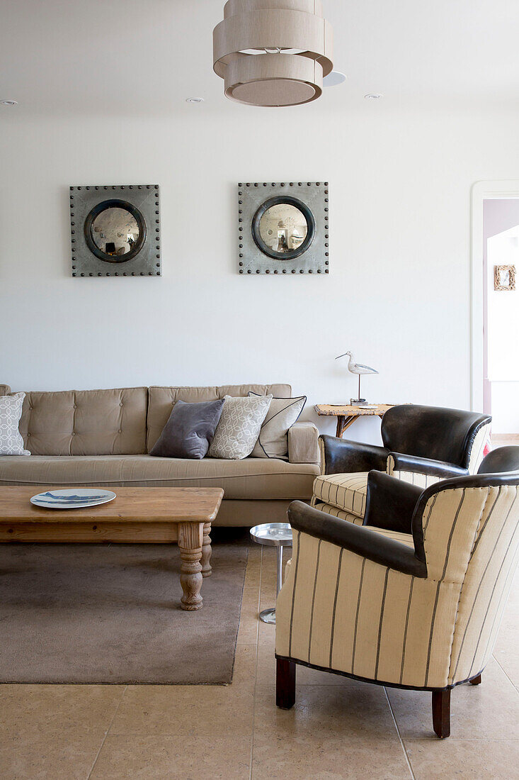 Konvexe Spiegel über dem Sofa mit hölzernem Couchtisch in einem Haus in West Wittering, West Sussex, England