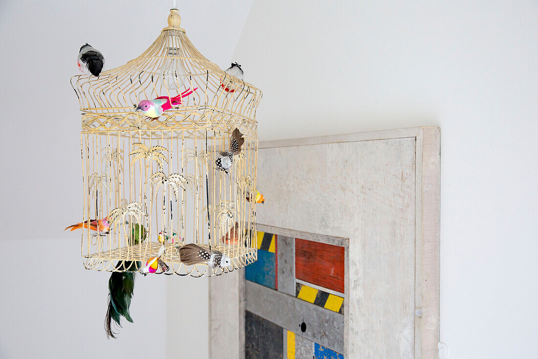 Modellvögel auf einem Vogelkäfig aus Metall in einem Haus in West Wittering, West Sussex, England
