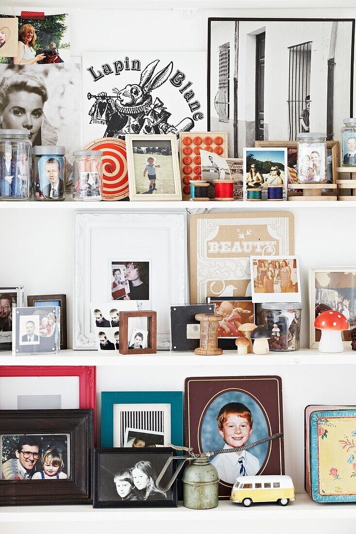 Photographs and ornaments on white shelves in London family home,  England,  UK